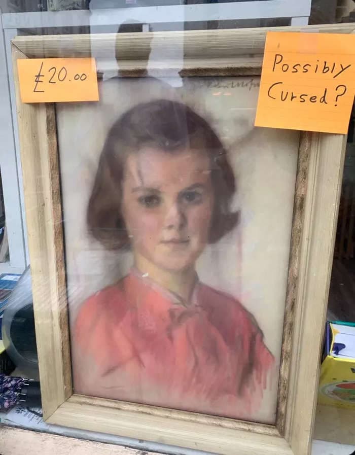A creepy portrait at a UK charity shop went viral for being 'possibly cursed.' But the shop manager says 'nothing evil happened here' and wants people to stop calling him.