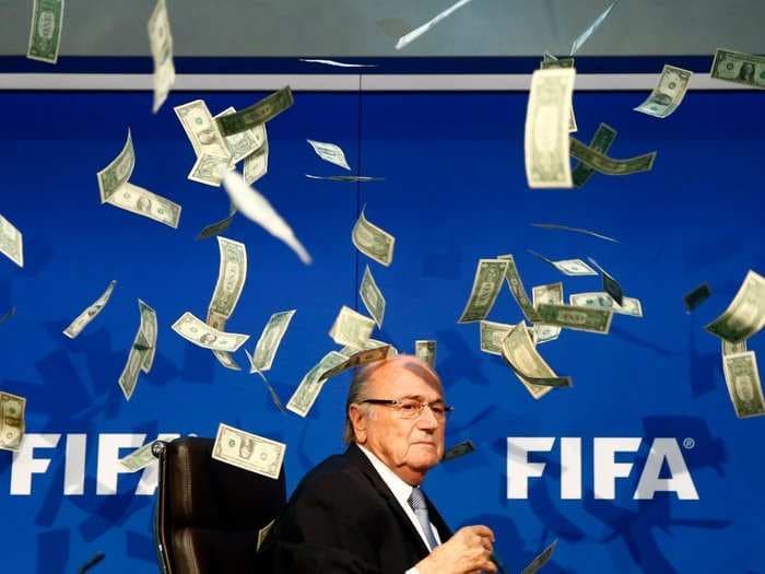 A protester threw a stack of fake money at FIFA president Sepp Blatter during a press conference
