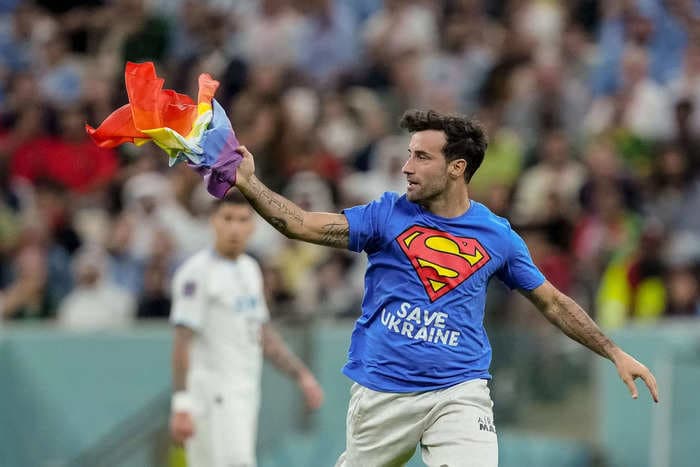 World Cup protester invades field holding rainbow flag and wearing T-shirt that read 'Save Ukraine' and 'Respect for Iranian Woman'