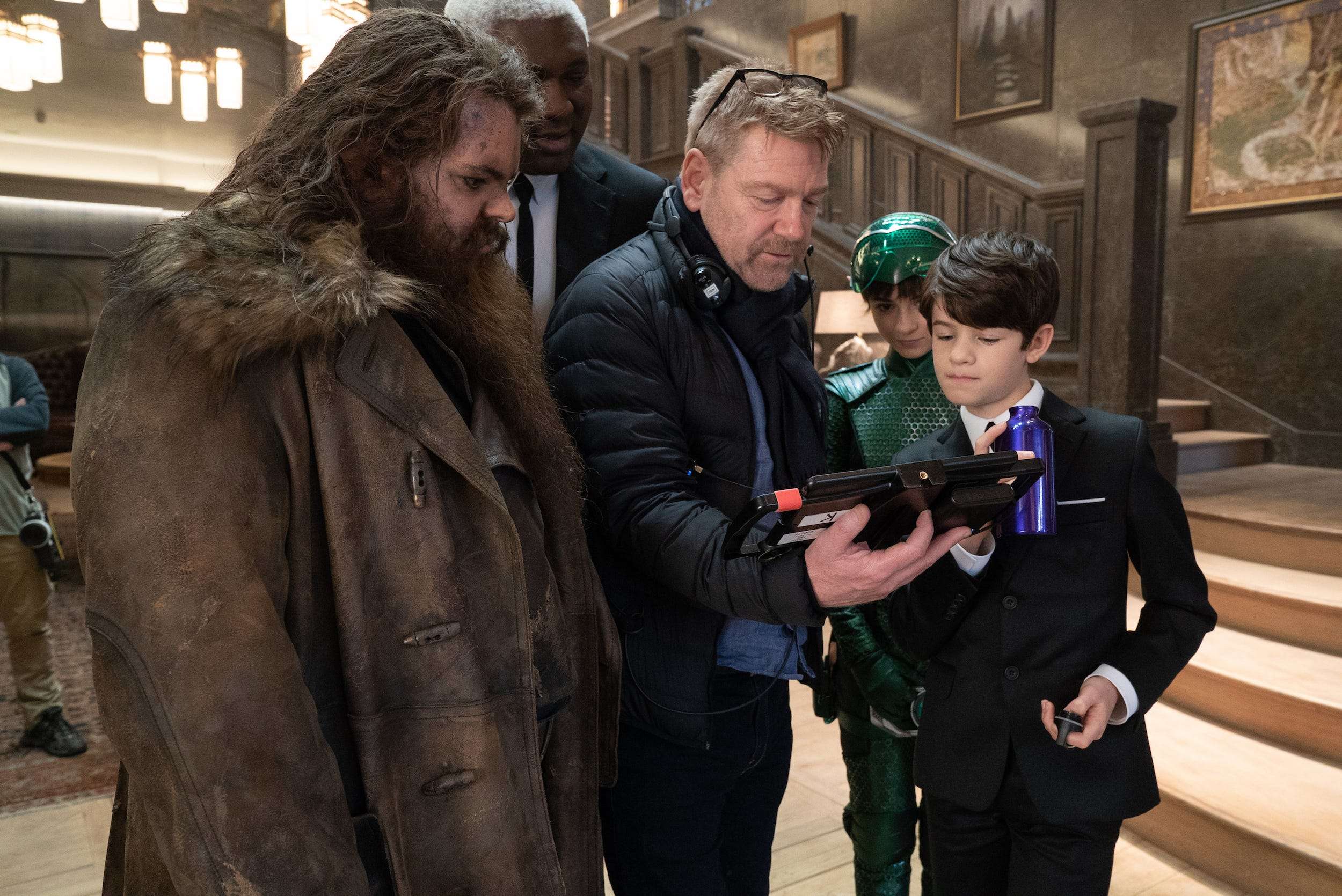 A behind-the-scenes photo shows director Kenneth Branagh with Josh Gad, Non...