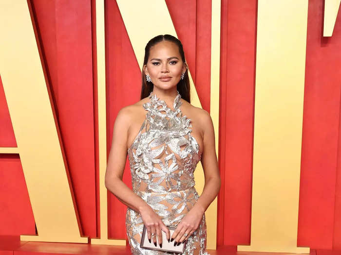 Chrissy Teigen arrived in a barely-there gown crafted from silver fabric.