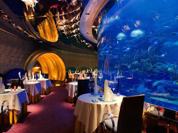 Al Mahara, which is located inside Dubai's luxurious Burj Al Arab hotel, claims to have the best seafood in Dubai. The restaurant's golden archway leads into a dining room built around a stunning aquarium, so guests can watch sharks, sting rays, and fish swim past as they dine.