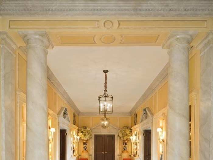 The entryway of the apartment on the 10th floor the building opens to a grand gallery with marble columns and multiple chandeliers.