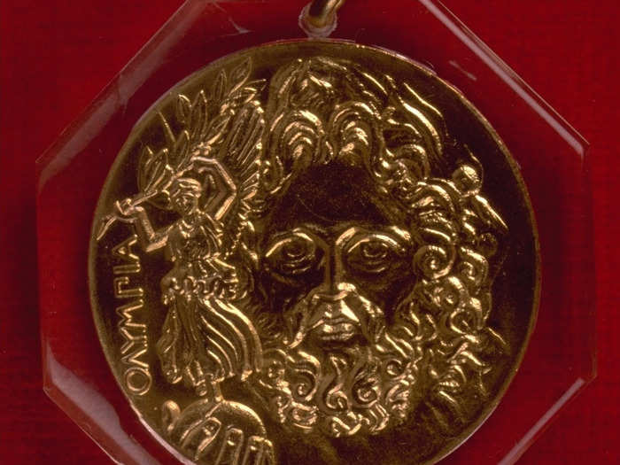 ATHENS 1896: Winners at the first Olympics of the modern era received a silver medal. The front of the medal depicts the Greek God Zeus' face, and he's holding a globe with the goddess of victory Nike on it.