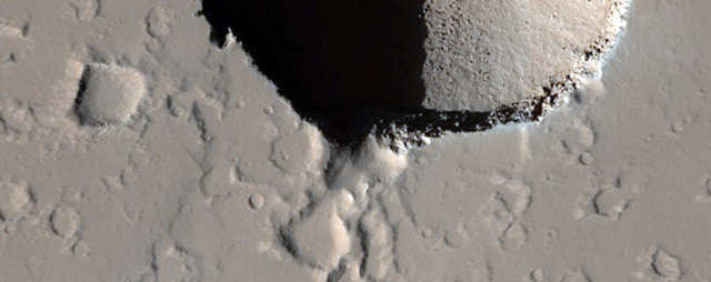 A pair of collapse pits in Ceraunius Fossae.