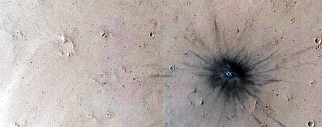 Uma recente cratera de impacto em Marte.  (Temos certeza que ninguém colocou um cigarro gigante aqui.)