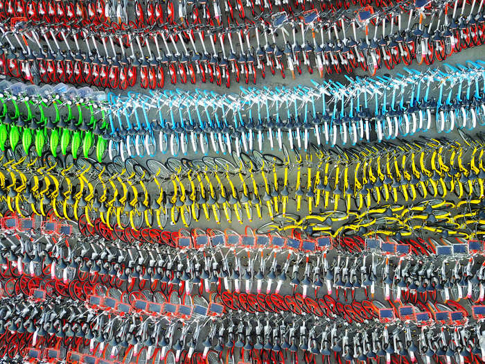 A rainbow of bicycles sits at a parking lot in Shanghai, China.