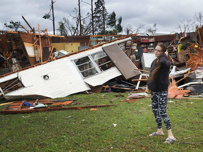 A woman stands in front of what is left of one of her father's trailer homes after hurricane Michael passed over Panama City on Wednesday.