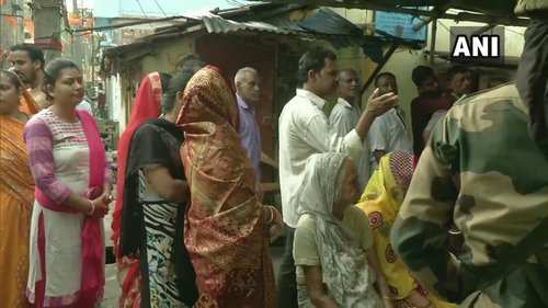 Voters queue up outside a polling station in Barrackpore in West Bengal: ANI