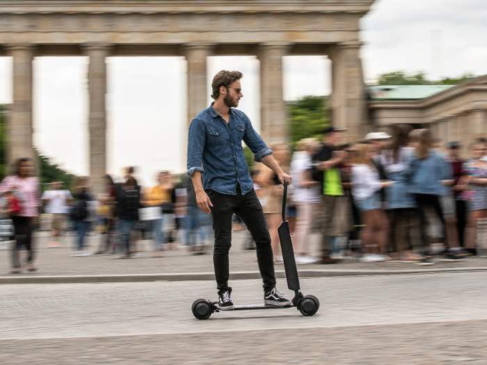  Audi says the e-tron Scooter can reach speeds up to 12.5 mph in a straight line, but can also handle "unusually tight curves" due to the movable axles and four wheels. 