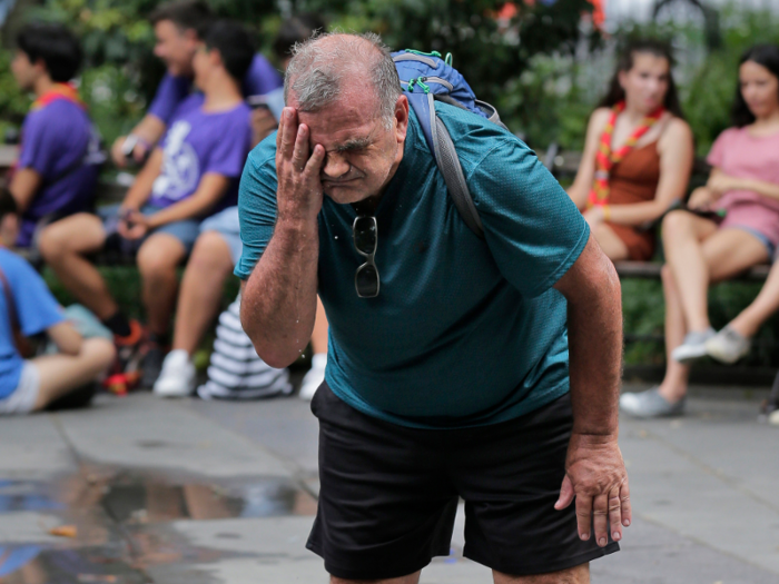 In New York, a man splashes his face in July, using a fountain as best he can.