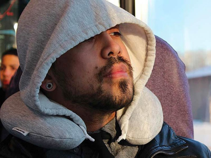 A travel accessory that combines a hoodie with a memory foam pillow