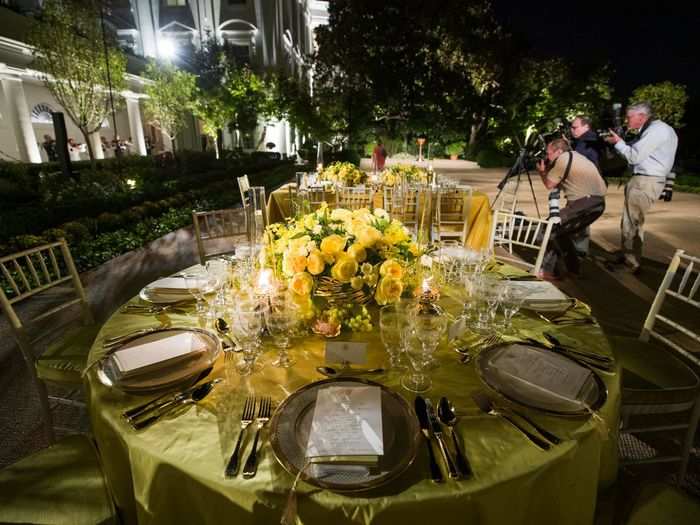 The color scheme for the evening is green and gold in a nod to Australia's national flower. White and yellow roses will fill the Rose Garden, where the dinner will take place. The centerpieces alone are made of 2,500 roses.