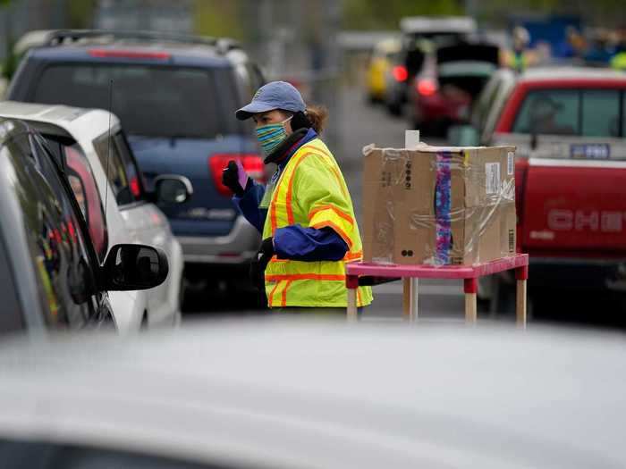 A volunteer registers families waiting to collect food from a drive-through food bank in LaGrange, Kentucky.