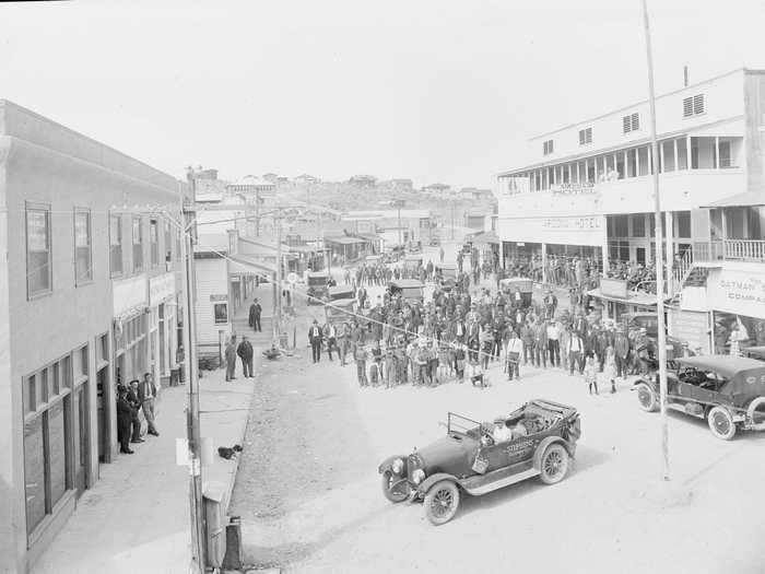 Oatman, Arizona, started as a mining town after gold was found nearby in the early 1900s. Townspeople and old cars are seen in the town below in 1922.
