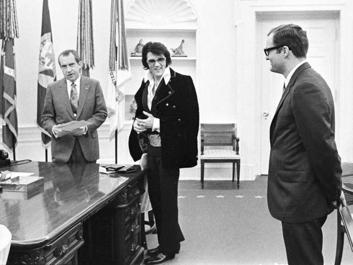 Elvis looked dapper for a 1970 meeting with Richard Nixon. He wore a velvet jacket, layered shirts, an oversized belt buckle, and aviator shades.