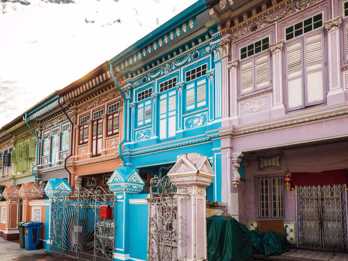 Many streets in Singapore are lined with narrow, terraced homes painted in candy-colored shades of blue, pink, and green. These homes are called shophouses, and they tend to be two or three floors high.