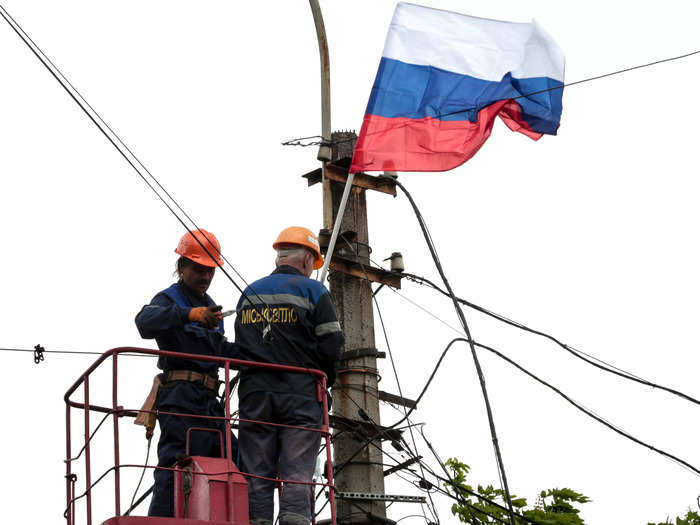Russia has begun installing its flags in besieged Ukrainian cities.