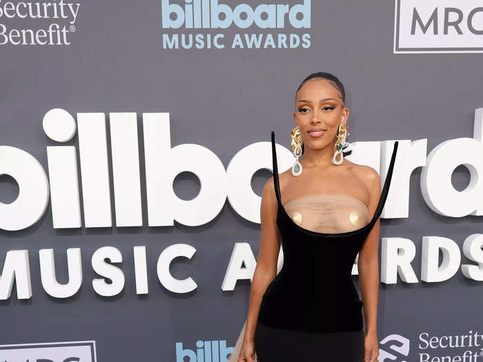 Doja Cat stole the show in a risqué black corset with a sheer nude panel over her chest and gold pasties.