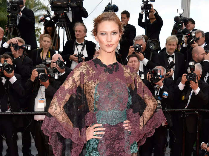 Karlie Kloss attended the Cannes Film Festival in 2014 wearing a maroon and green sheer gown.