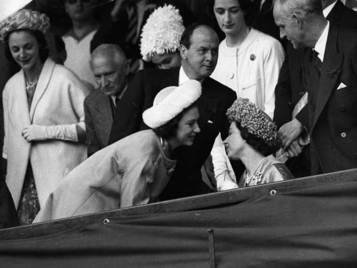 Queen Elizabeth II and Princess Margaret lean in for a chat while at the men's final at Wimbledon in 1962.